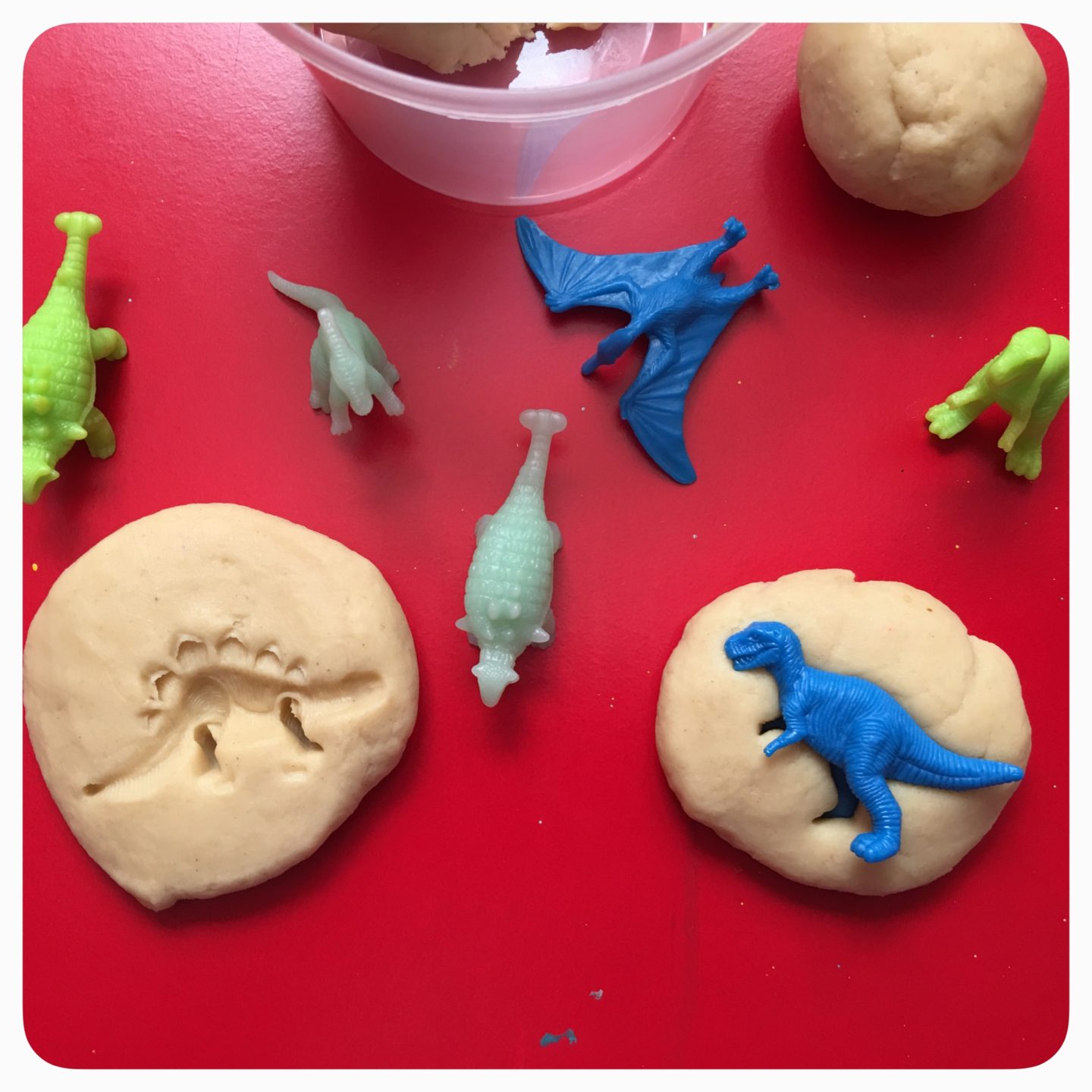 Creating simple play-dough invitations to play for exploring Dinosaurs.