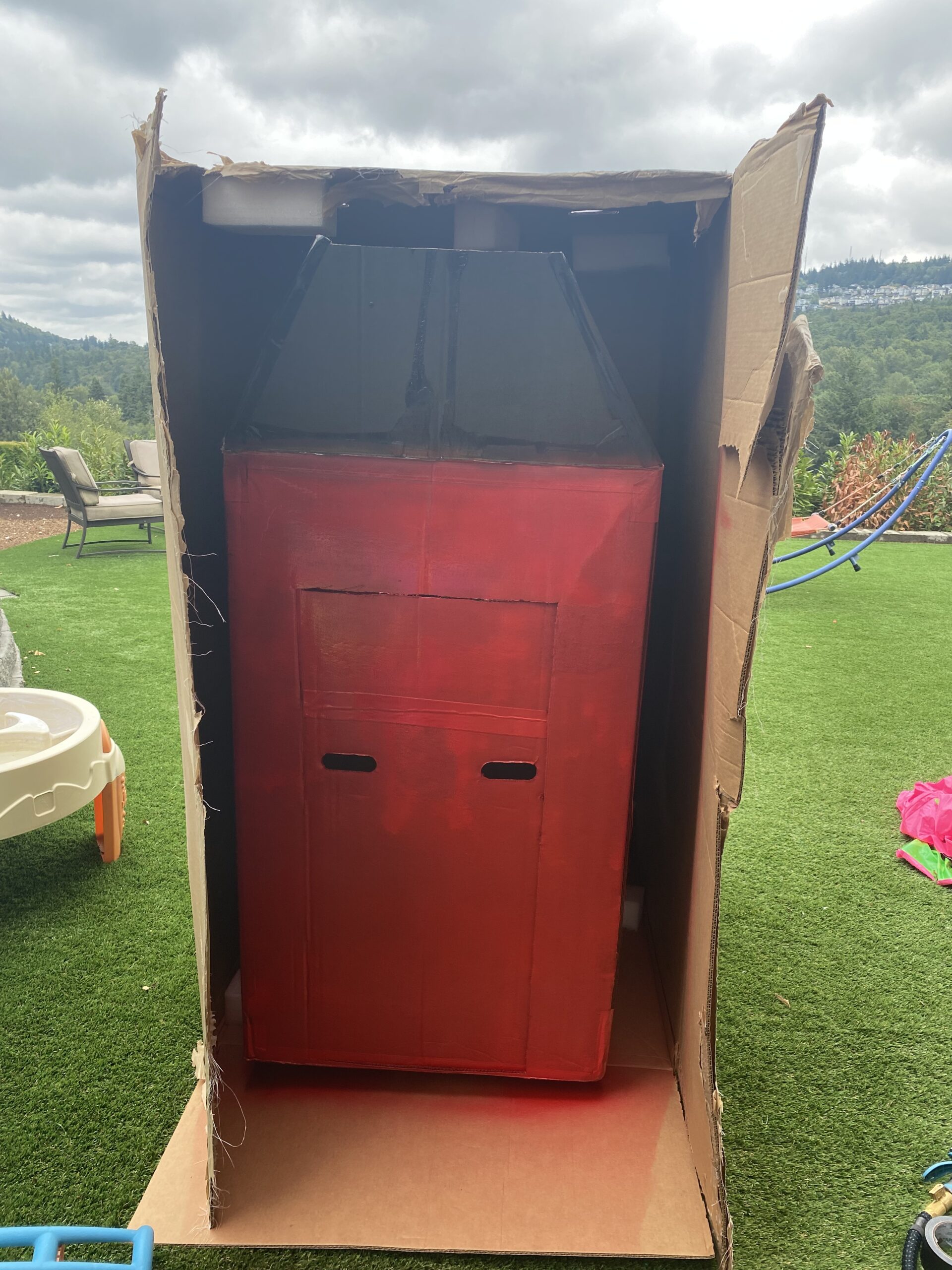 I started out by using spray paint in red and black but due to the smell, I had to keep creating outside.  It started to rain and so I tried to hide our large Barn box inside of another large box.  The spray paint didn’t cover all of the black ink so I switched to using acrylic paint. 